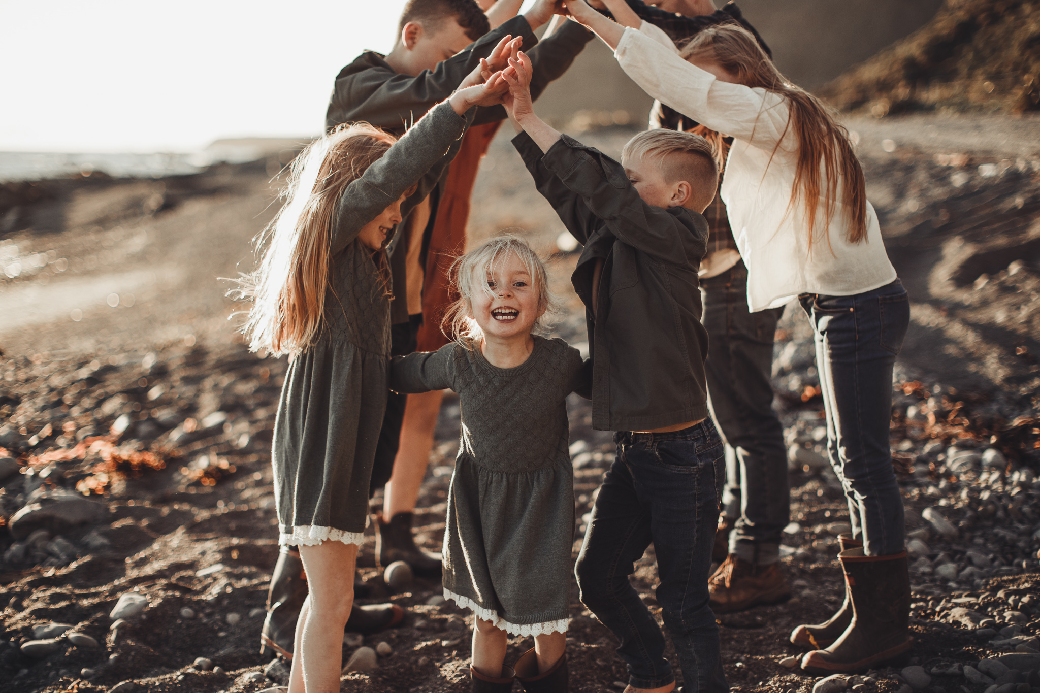 family playing at the beach sunset