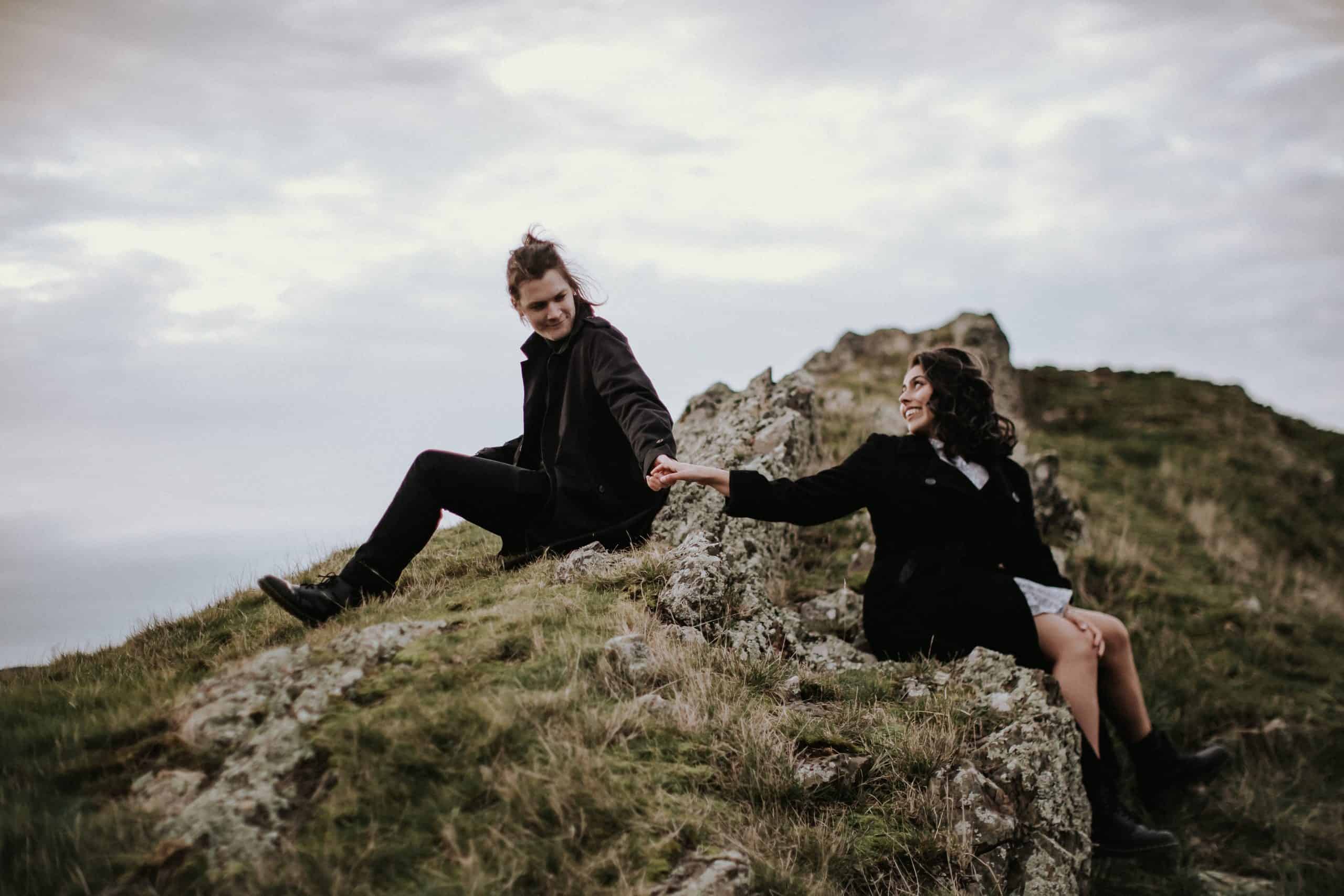 engagement shoot couple hold hands on rocks